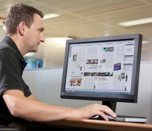 A printer sitting in front of a computer looking a graphics