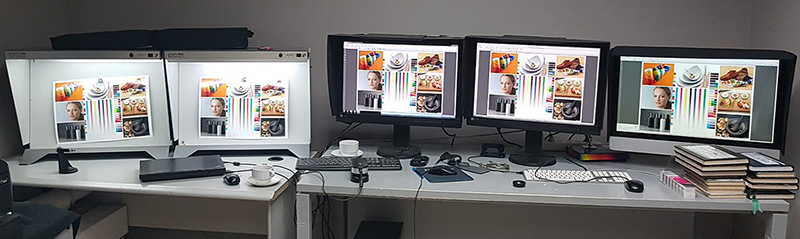 Photo of computer monitors and color light box testing station.