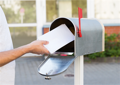Man putting a letter in a mailbox