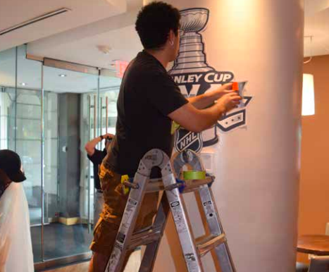 Crew hanging a Stanley Cup Final 2018 Banner Indoors