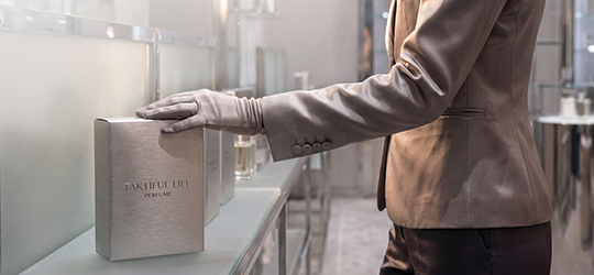 a gloved person in business clothes touches a luxurious-looking silver box