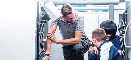 Three Printer Technicians looking at a printing equipment