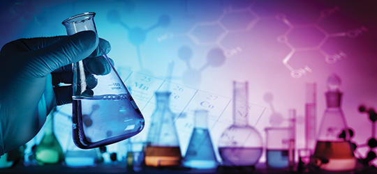 hand holding a beaker of liquid