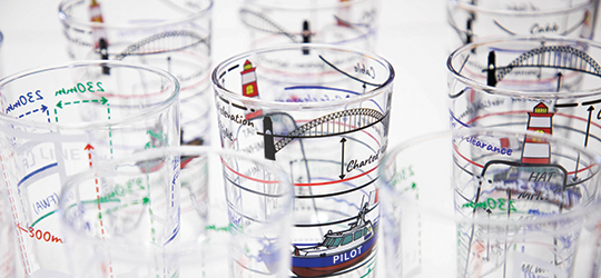 glass cups with images of boats and lighthouses printed on them