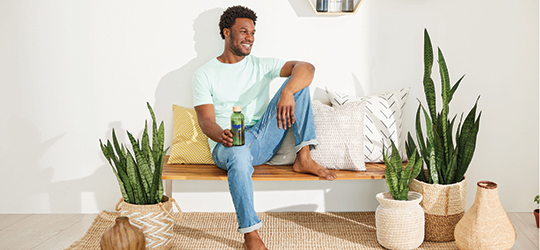 happy man sitting on a bench with a bottled drink