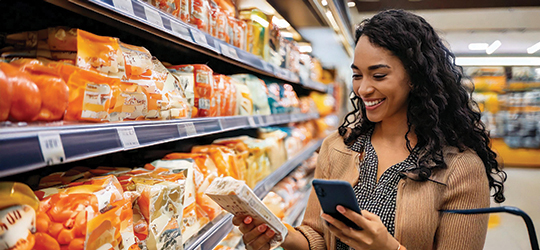 woman in a grocery store smiles while looking at package with interactive print