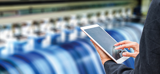person using a tablet to monitor a printer